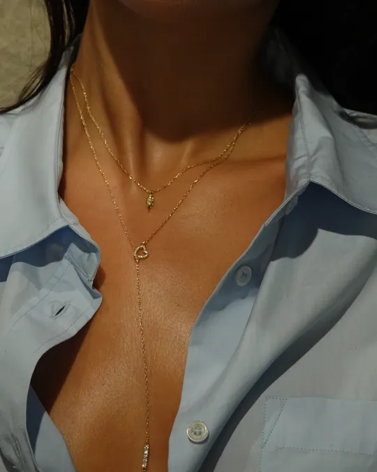 Auburn Jewelry photo: layered gold necklaces with a small charm and a heart pendant